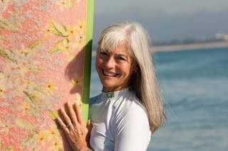 Smiling Elder Lady Holding Surfboard