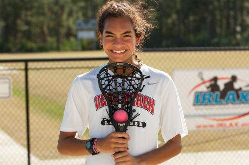 Teenager smiling holding lacrosse racquet 
